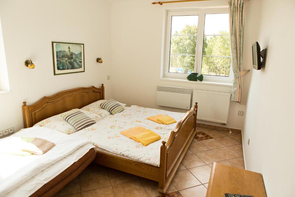 um quarto com uma cama e uma janela em Pivovarský dvůr Zvíkov em Zvíkovské Podhradí