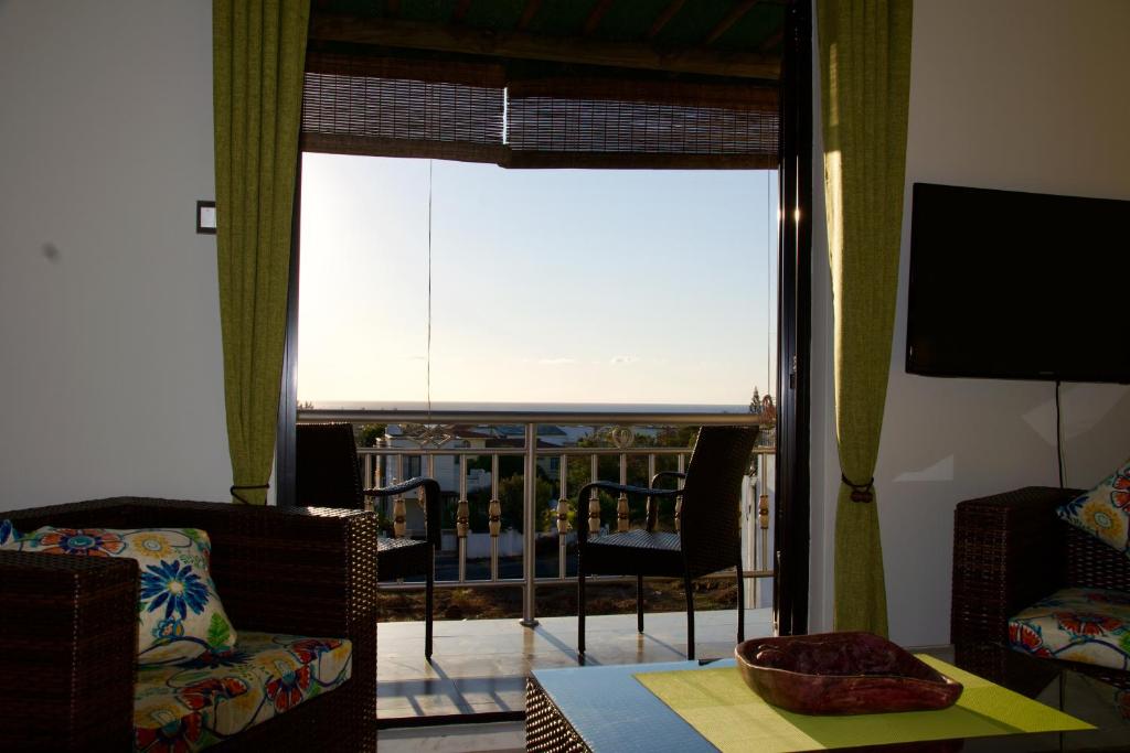 ein Wohnzimmer mit einem Fenster mit Blick auf einen Balkon in der Unterkunft Zanana Penthouse in Palmyre
