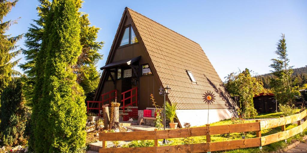 a house with a pointed roof and a fence at Fichtelgebirgshaus in Fichtelberg