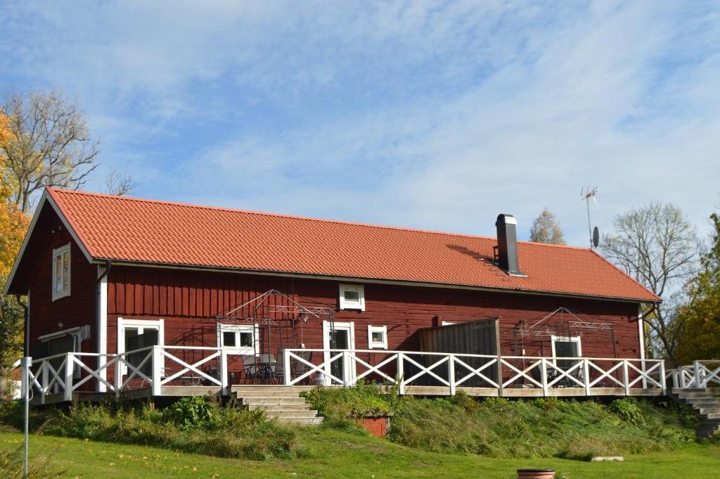 un granero rojo con techo rojo en Ekengård, en Köping