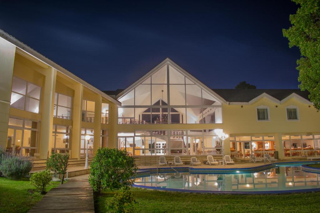 una grande casa con piscina di notte di Parque Hotel Jean Clevers a Punta del Este