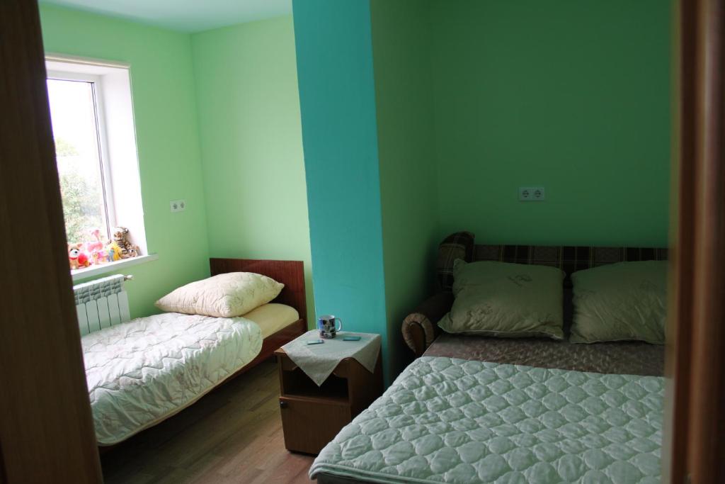 パヴロフスクにあるGuest house on 1 Maya 50の緑の壁のベッドルーム1室(ベッド1台、窓付)