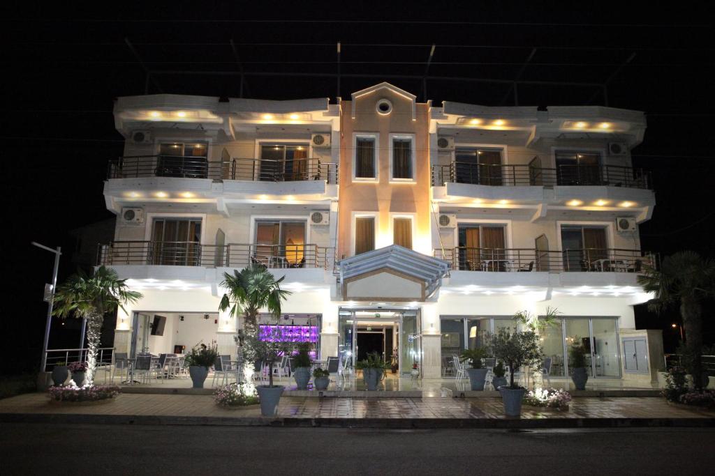 a large white building at night with a sign in front at Kallisti in Nei Poroi