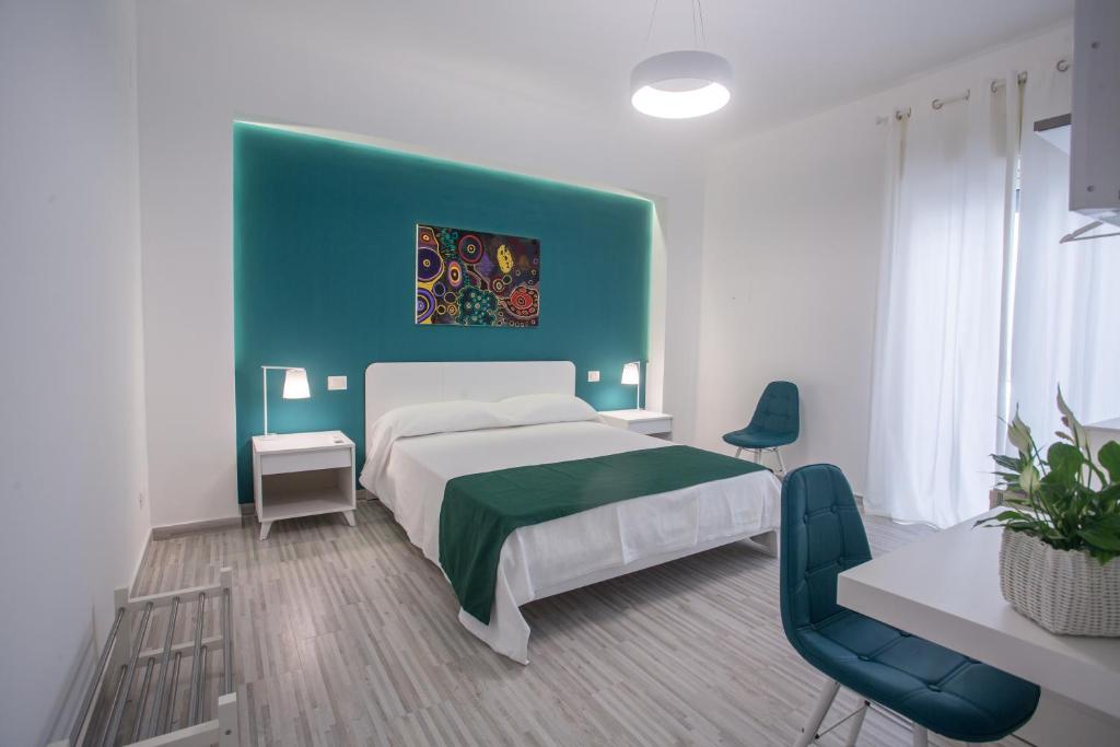 a bedroom with a bed and a blue wall at B&B al Centro in Messina
