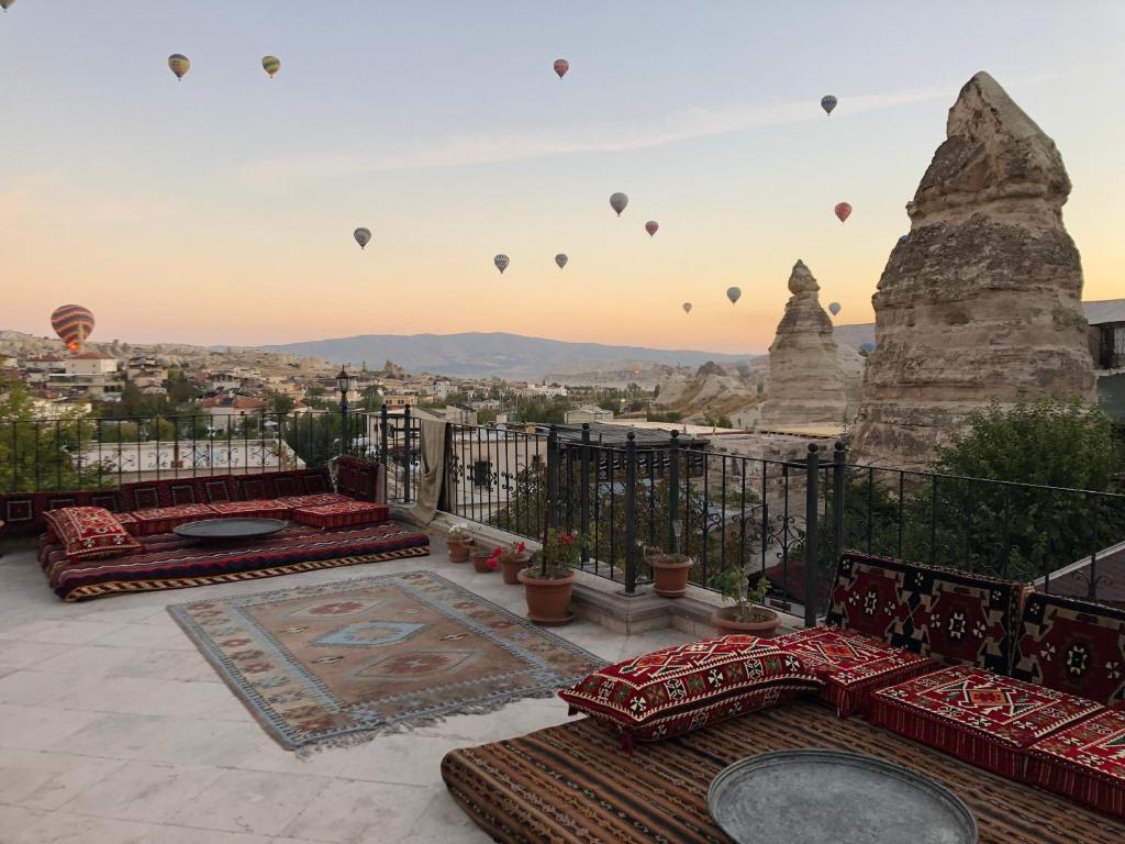 a balcony with hot air balloons flying over a city at Cappadocia Stone Palace in Goreme