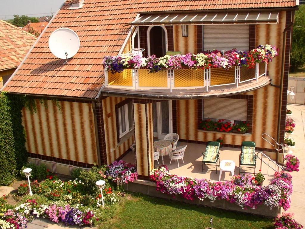 a house with a balcony with flowers on it at Amália Apartman in Gyula