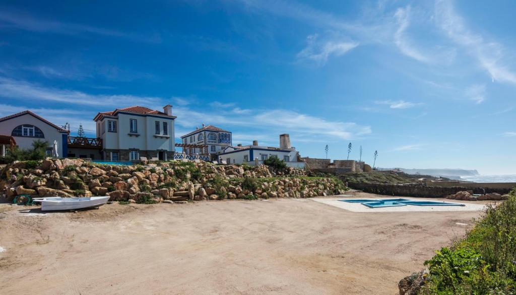 a sandy beach with a house and a building at Chalet O Amorzinho Sintra Praia in Sintra