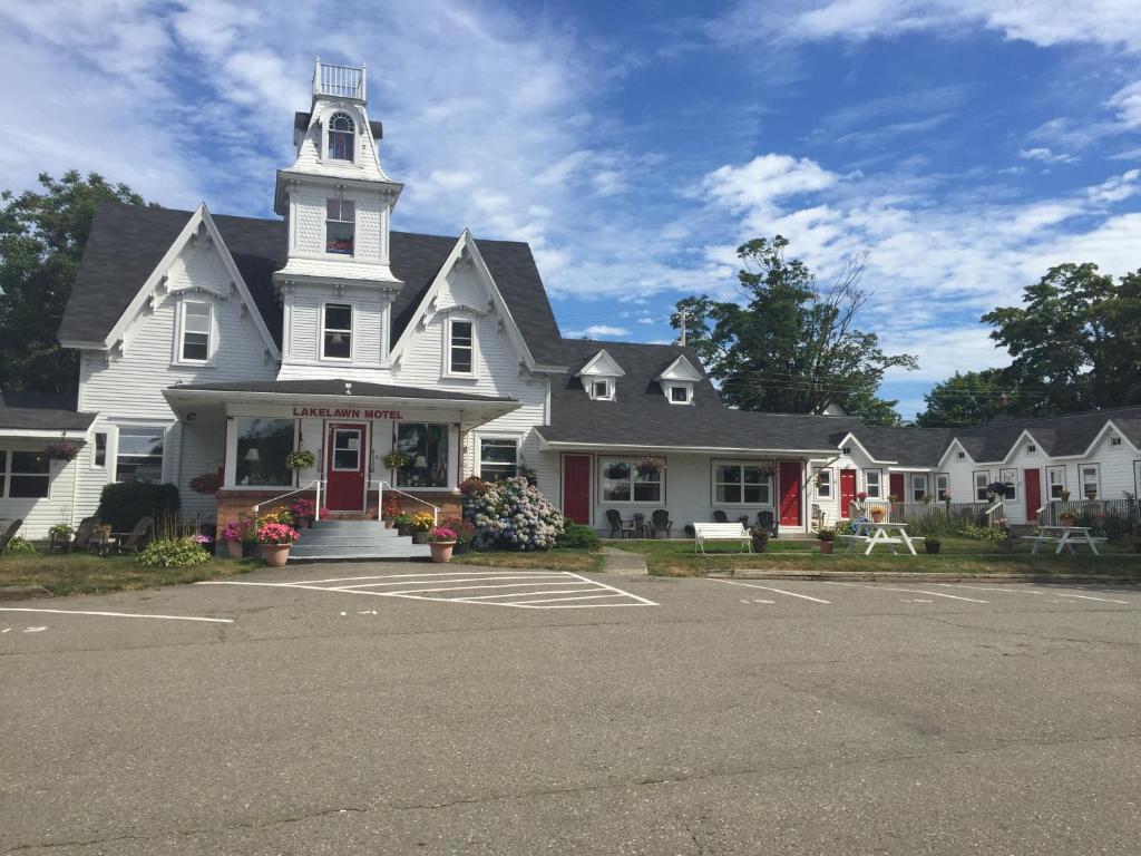 a white house with a tower on top of it at Lakelawn B&B and Motel in Yarmouth