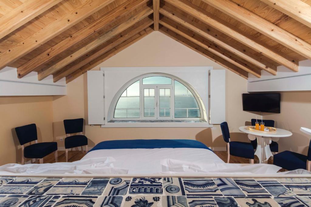 a bedroom with a large bed and a window at Chalet O Amorzinho Sintra Praia in Sintra