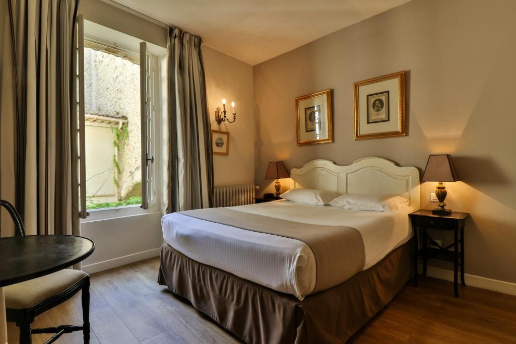 une chambre d'hôtel avec un lit et une fenêtre dans l'établissement Hotel Du Midi, à Visan