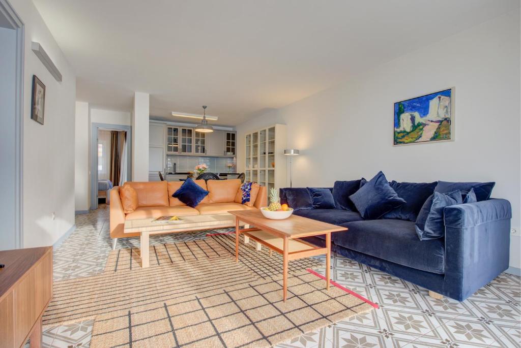 プエルト・デ・サンティアゴにあるModern, bright and welcoming oceanfront apartmentのリビングルーム(青いソファ、テーブル付)