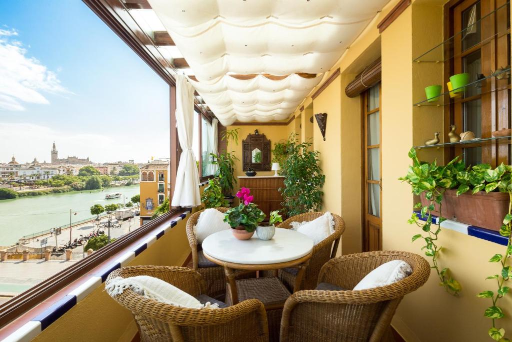 balcón con mesa, sillas y ventana en Veoapartment Casa Trianamirador, en Sevilla