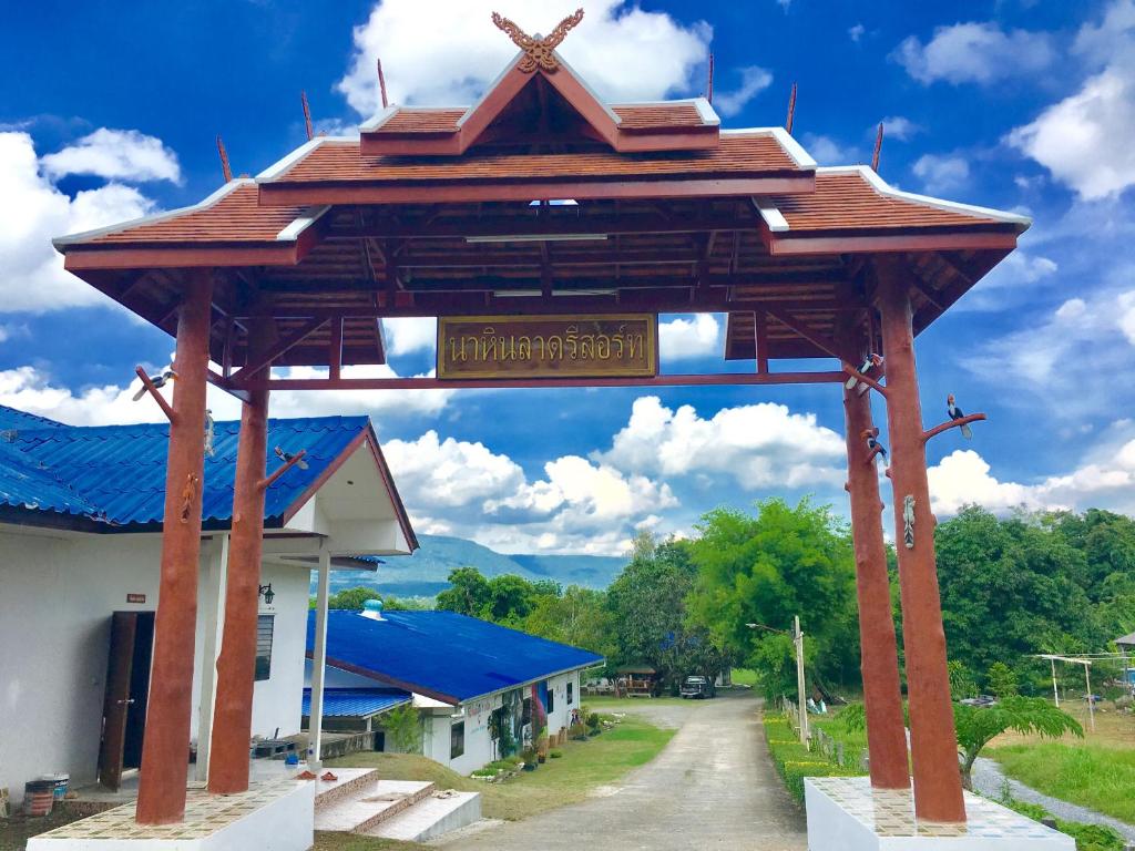 a large wooden arch in front of a building at นาหินลาดรีสอร์ท Nahinlad Resort in Ban Khok Sawang (2)
