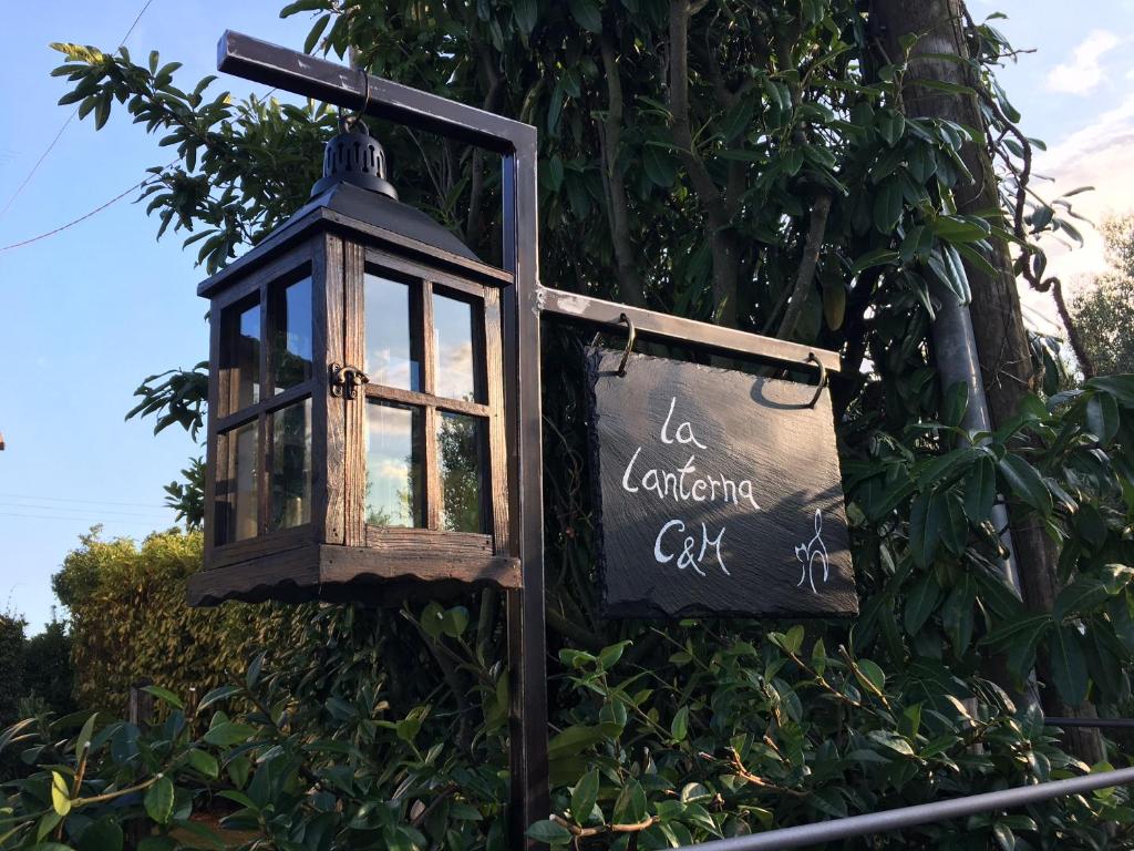 ein Straßenlicht mit einem Schild vor einem Baum in der Unterkunft La Lanterna Camere & More in Quinto Vicentino