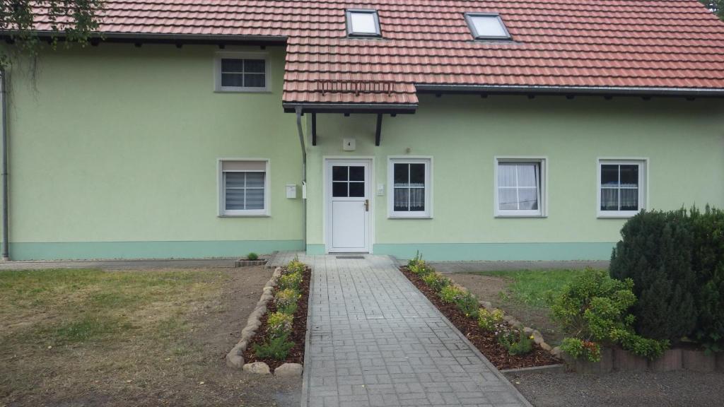 una casa con una porta bianca e un tetto rosso di Ferienwohnung am großen Stein a Leutersdorf