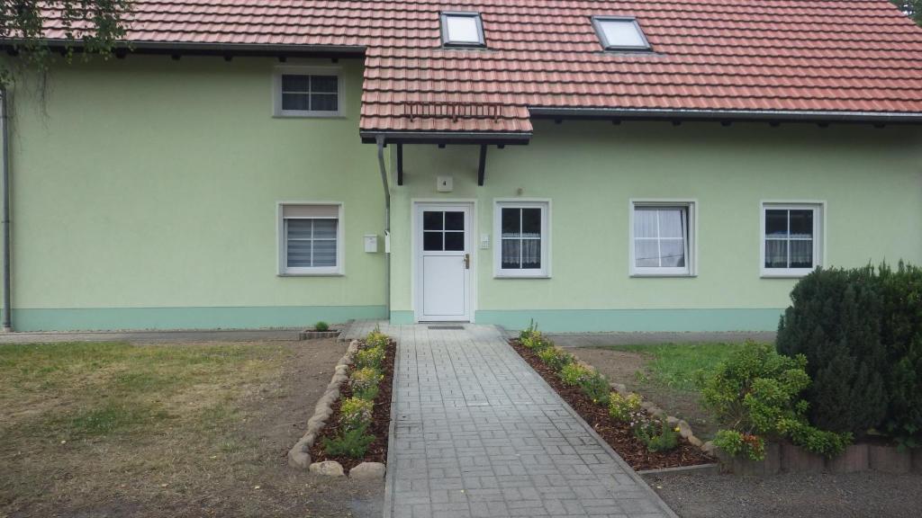 a house with a white door and a red roof at Ferienwohnung am großen Stein in Leutersdorf