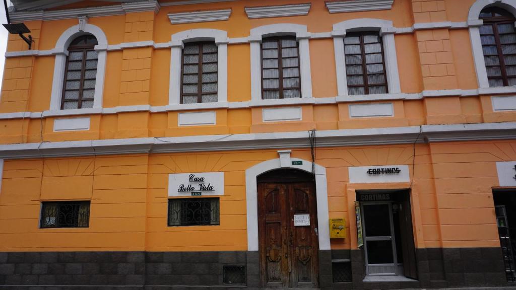 un edificio naranja con ventanas y una puerta en Casa Bella Vista, en Quito