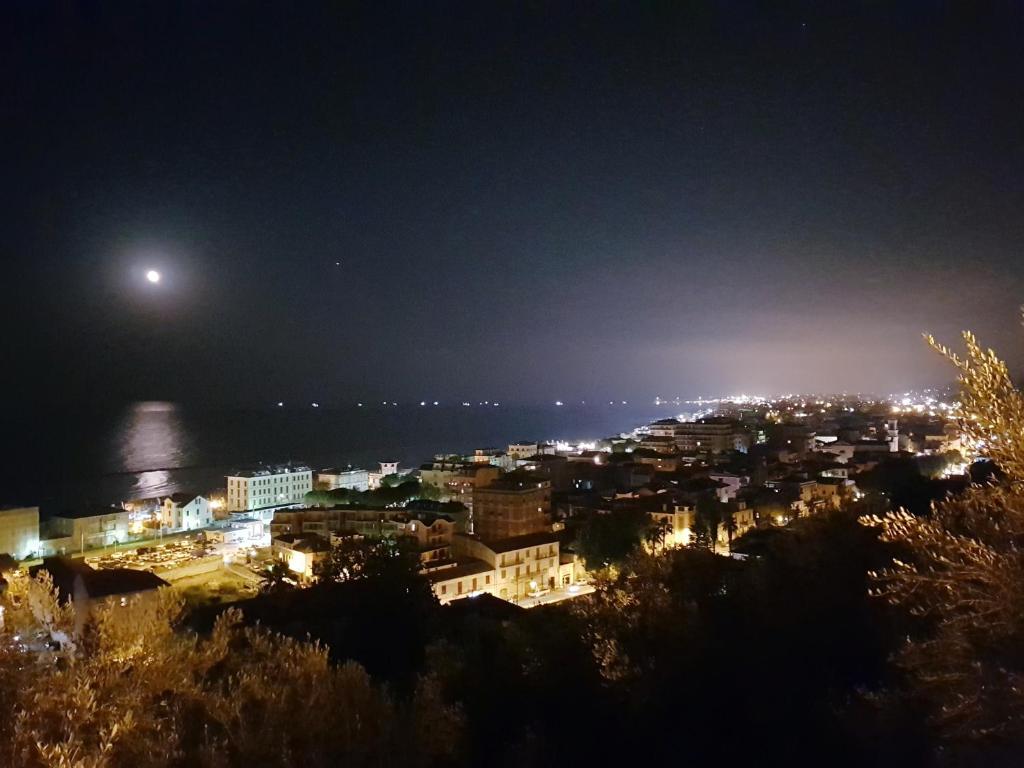 una città di notte con la luna nel cielo di B&B Porta Marina a Grottammare