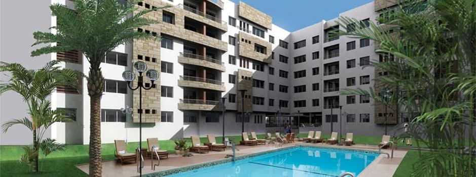 a hotel with a swimming pool in front of a building at Nouaceur Garden Airport Casablanca in Nouaseur