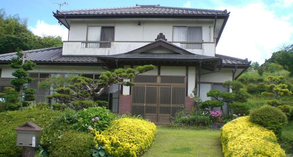 a house with a gate and bushes in front of it at Kakinoen / Vacation STAY 3939 in Nakagawa