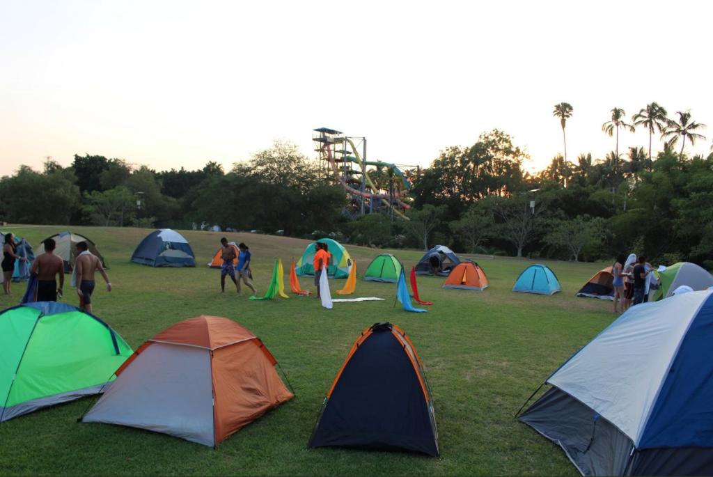 een groep tenten in een veld met mensen bij El Rollo Camping in Tlaquiltenango