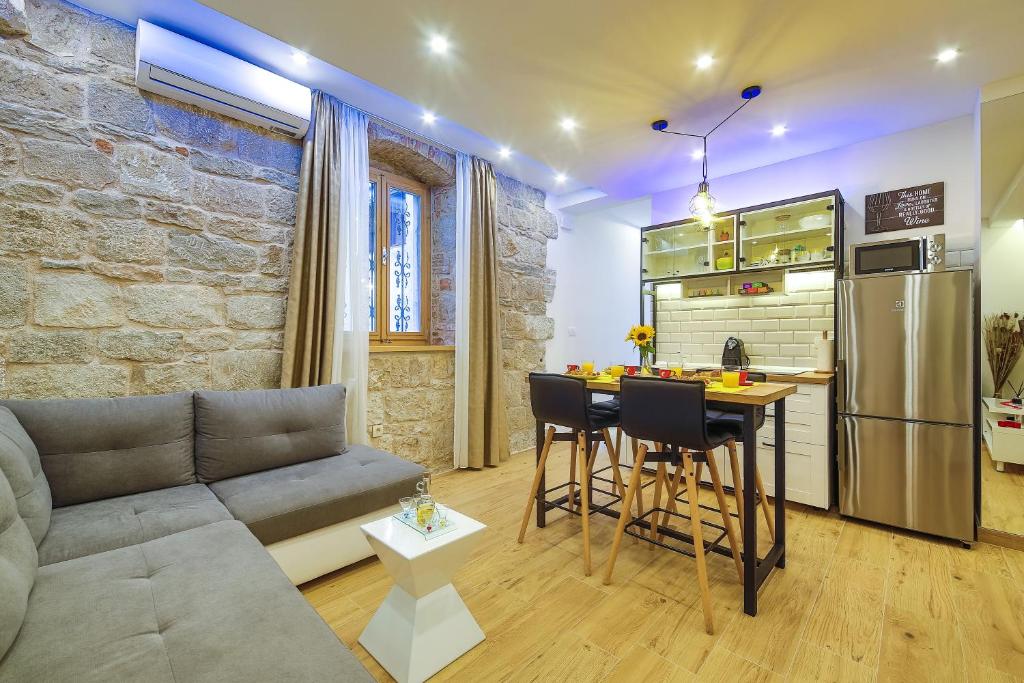 ein Wohnzimmer mit einem Sofa und einem Tisch sowie eine Küche in der Unterkunft Bacvice apartment Slavija in Split