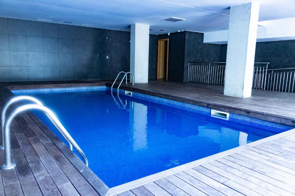 a swimming pool with blue water in a building at Forum Beach in Sant Adria de Besos