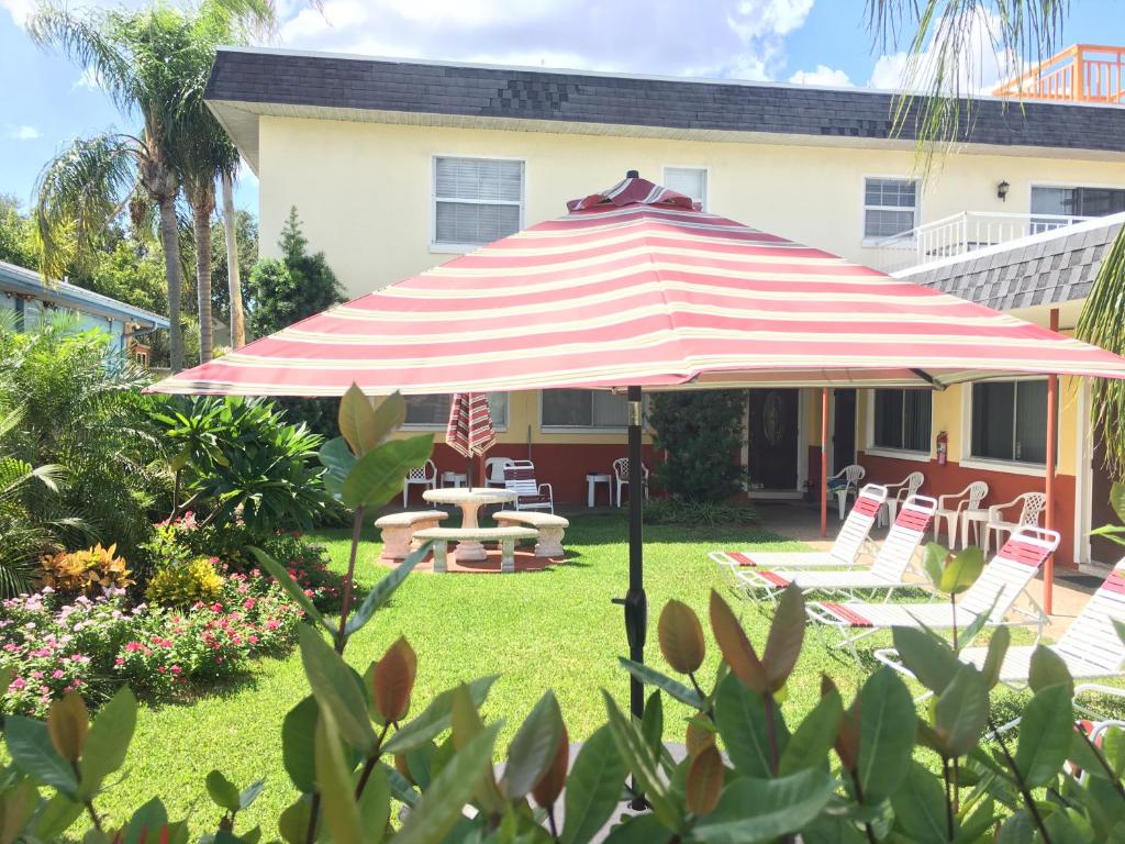 un paraguas rojo y blanco en el patio de una casa en Carousel Motel -Redington Shores en Redington Shores