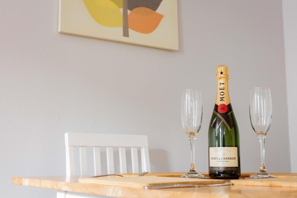 a bottle of champagne and two glasses on a table at Stirling Central Apartment in Stirling