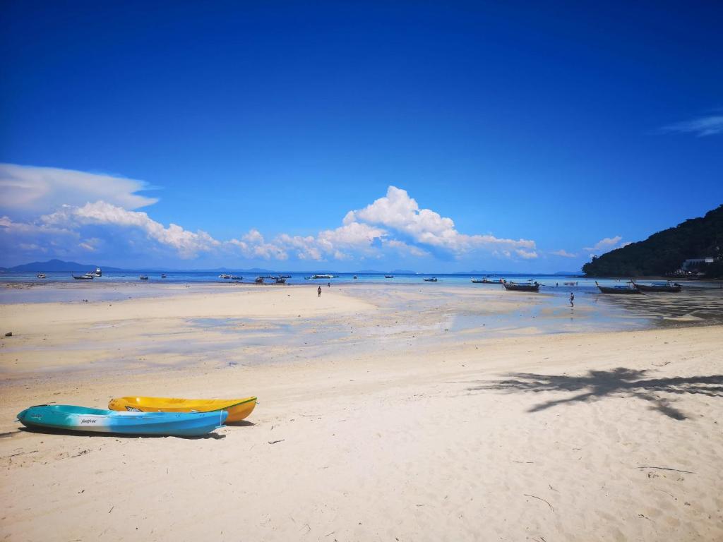 two kayaks on a beach with the ocean in the background at Phi Phi Ba Kao Bay Resort in Phi Phi Islands