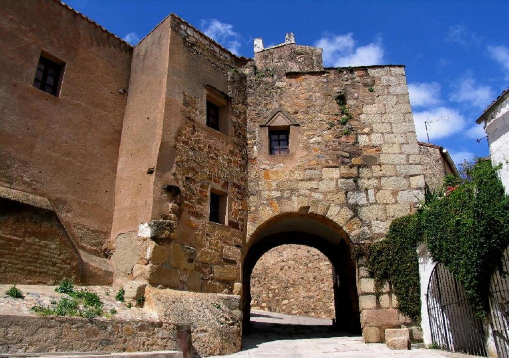 an old stone building with an archway at Apartamento Turístico MURALLA DE CÁCERES in Cáceres