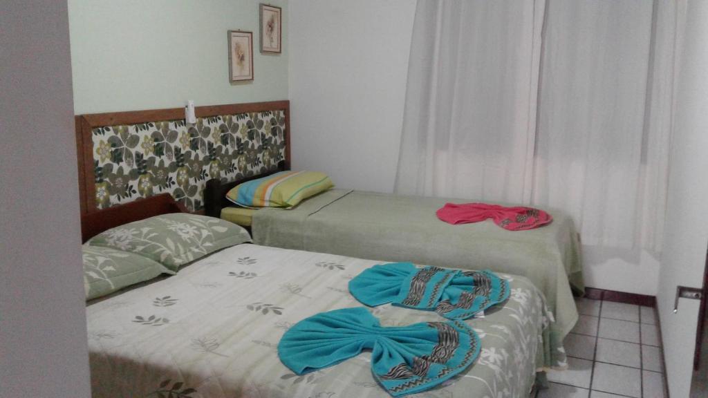 Dos camas en un dormitorio con toallas. en Residencial Três Irmas en Florianópolis