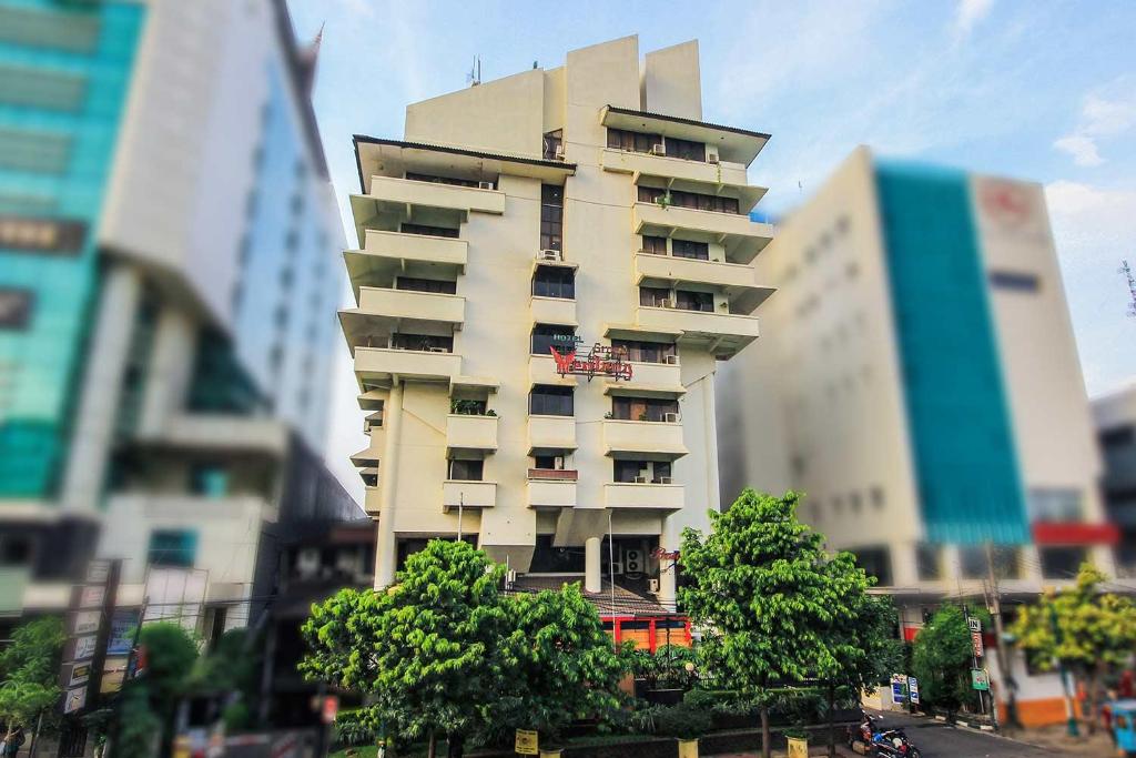 a tall building in the middle of a city at Grand Menteng Hotel in Jakarta