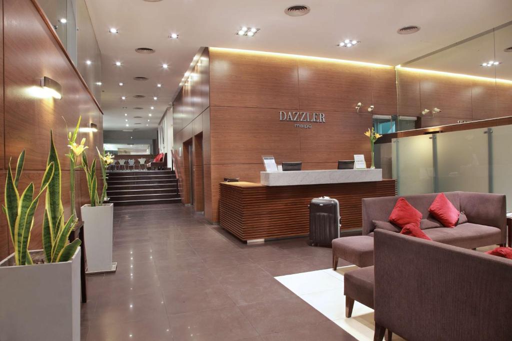 um átrio de um hotel com uma recepção e cadeiras em Dazzler by Wyndham Buenos Aires Maipu em Buenos Aires