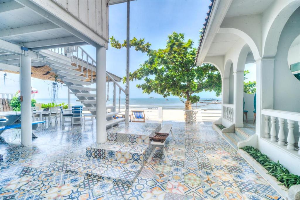 eine Terrasse mit einer Bank und Meerblick in der Unterkunft Khao Tao Beach Lodge Old Siam in Hua Hin