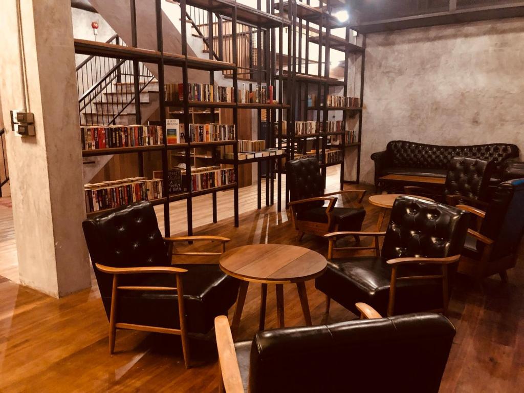a library with chairs and tables and bookshelves at The Chic Lipe in Ko Lipe