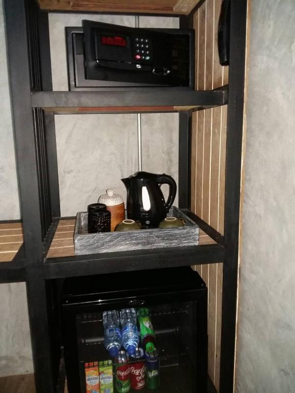 a small kitchen with a microwave and some drinks at The Chic Lipe in Ko Lipe
