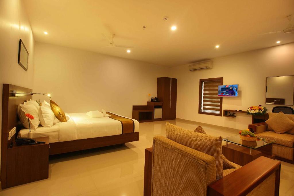 a bedroom with a bed and a living room at Victory Inn Park Residency in Kunnamkulam
