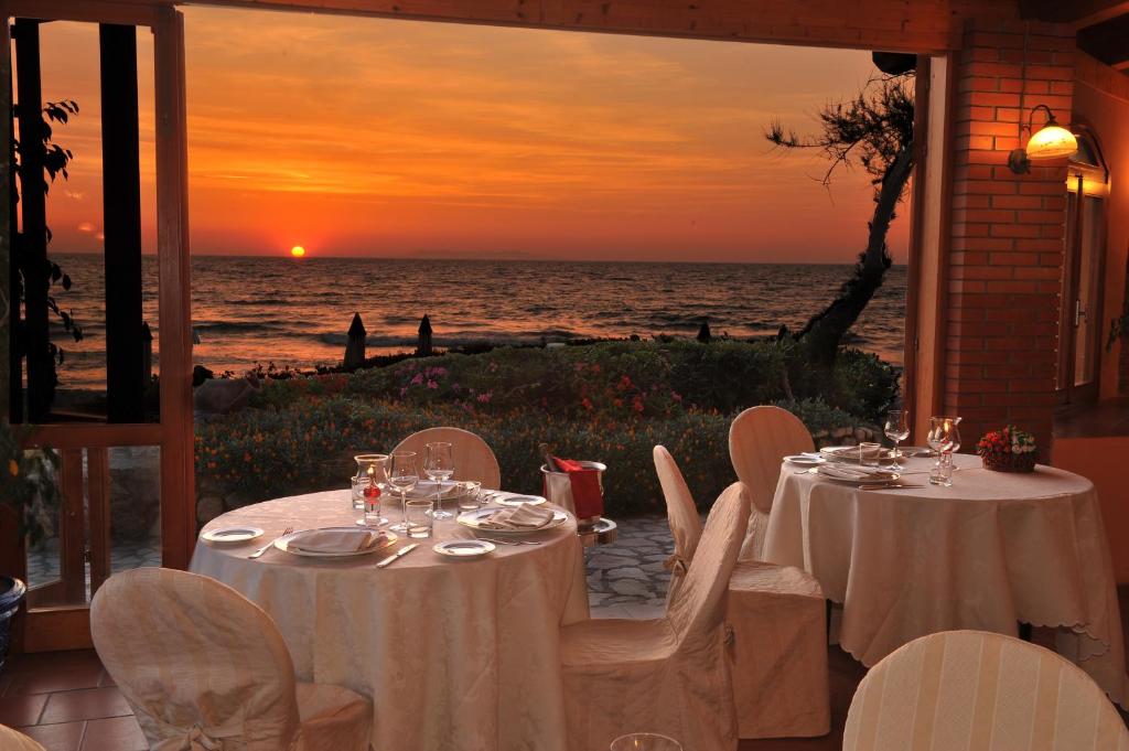 a table set up on the beach at sunset at Hotel Biodola in Portoferraio