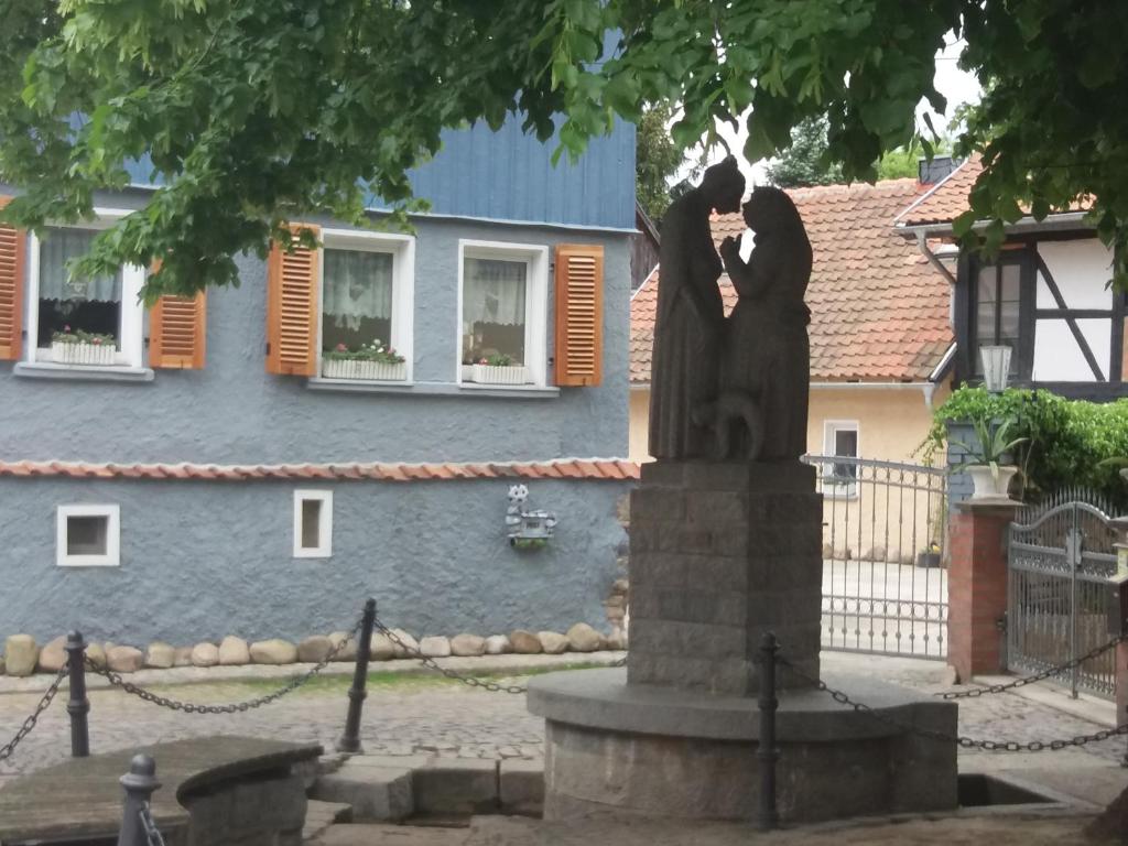 una estatua de una pareja besándose delante de una casa en Villa Windschief, en Thale