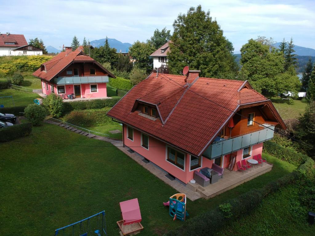 una casa con techo rojo y patio en Ferienhäuser Inge und Seeblick, en Oberaichwald