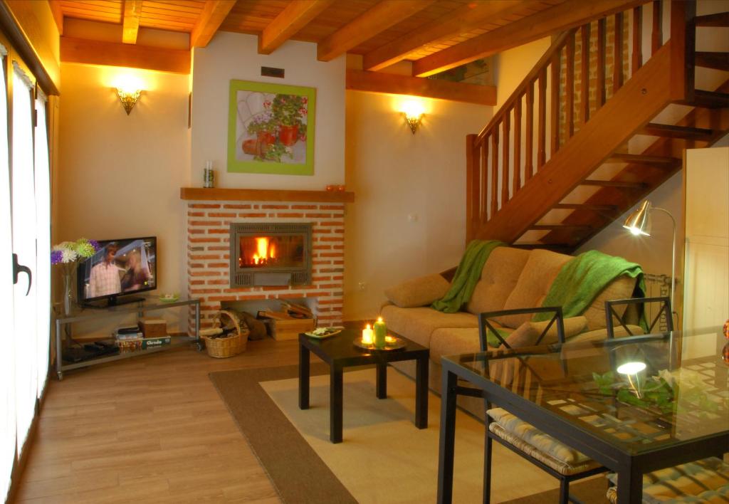 ein Wohnzimmer mit einem Sofa und einem Kamin in der Unterkunft La Casita de Adanero in Adanero
