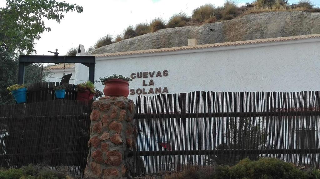 GraenaにあるCuevas La Solanaの塀と看板の白い建物