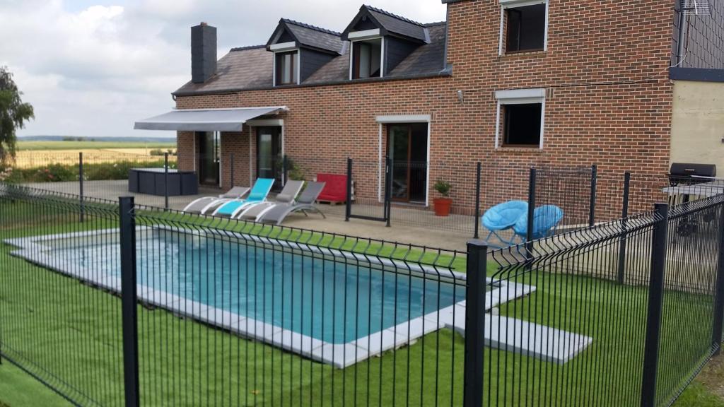 une clôture autour d'une piscine en face d'une maison dans l'établissement Le Clos de Ramousies, à Ramousies