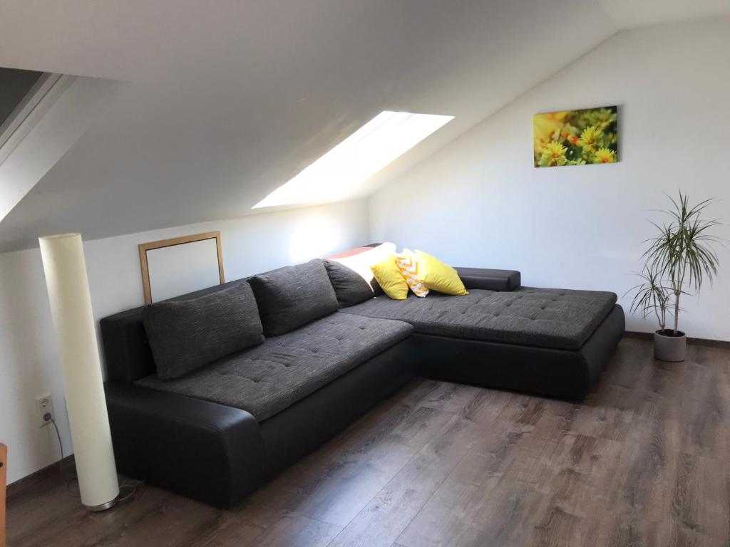 a black couch in a living room with a ceiling at Ferienwohnung Eimeldingen in Eimeldingen