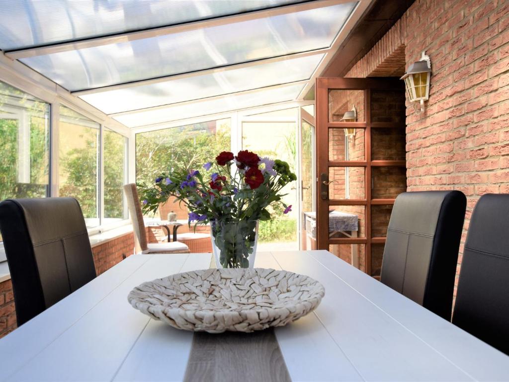un jarrón de flores sobre una mesa en una habitación en Modern Holiday Home in Graal-Muritz Germany with Garden, en Graal-Müritz