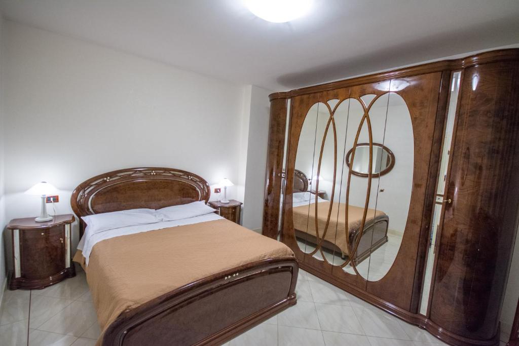 1 dormitorio con cama y espejo grande en City Center n. Two, en San Severo