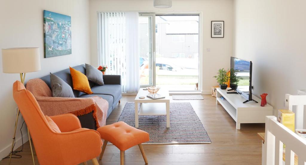 - un salon avec un canapé bleu et des fauteuils orange dans l'établissement Stones Throw, à Newquay