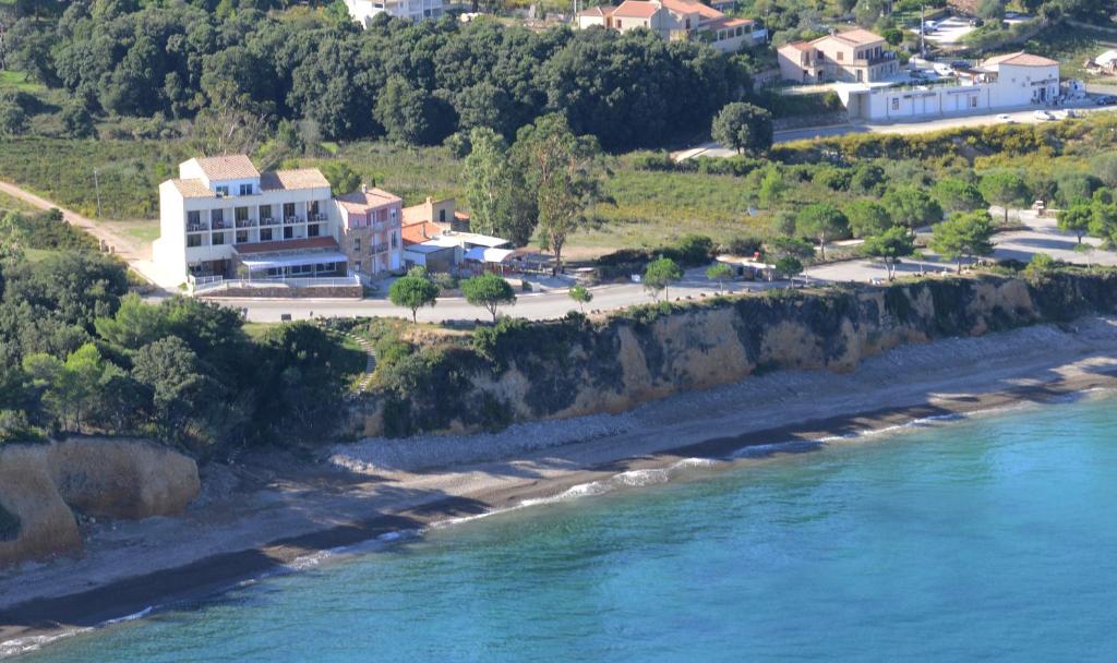 un edificio en una colina junto a un cuerpo de agua en Hotel Restaurant Le Filosorma, en Galeria