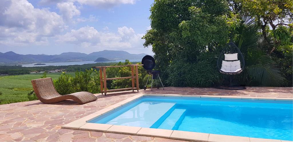 una piscina con sedie e vista sull'acqua di Résidence BelKay - Sur La Baie a Ducos